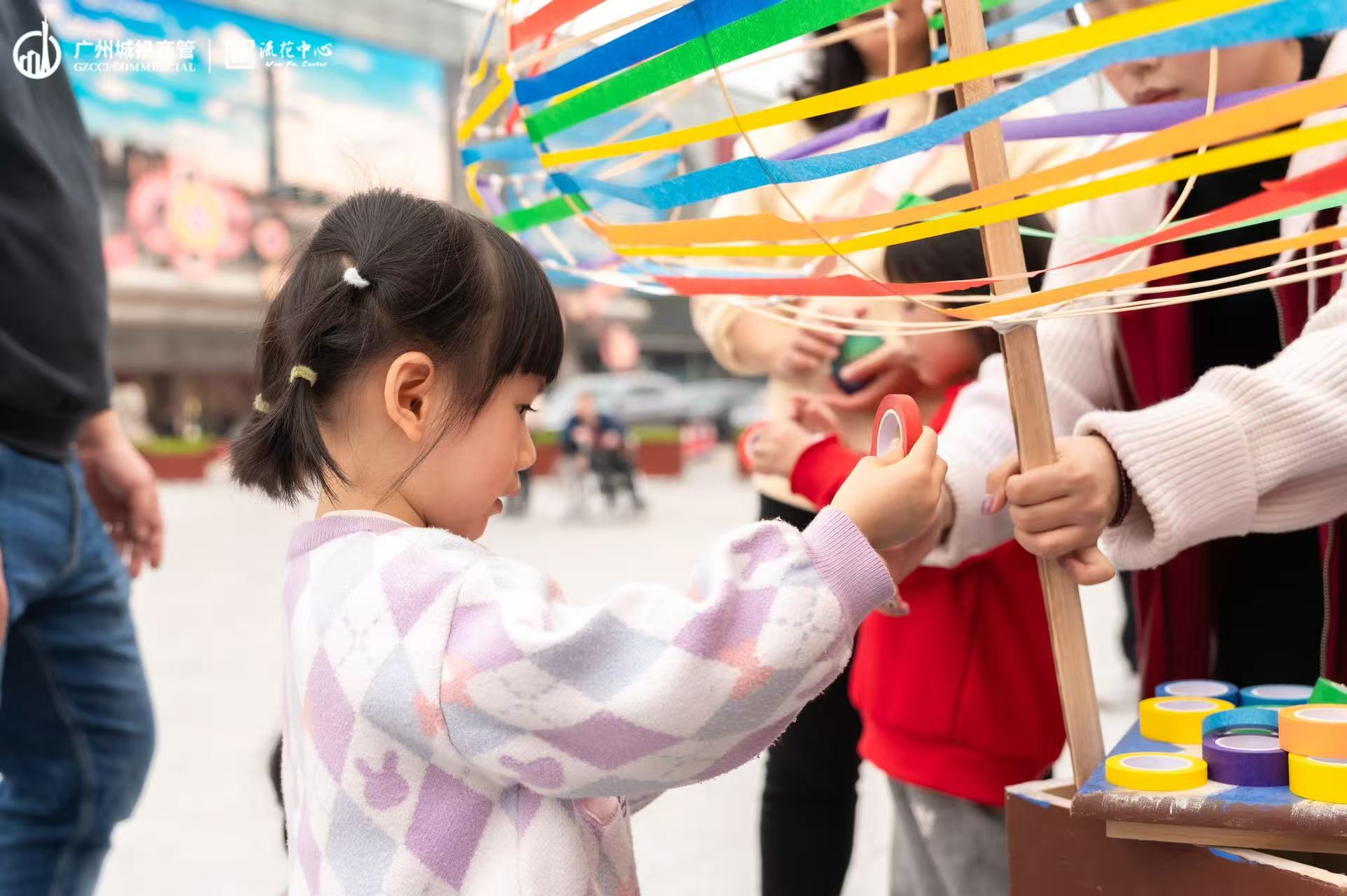 A child making a colorful fish lantern puppet